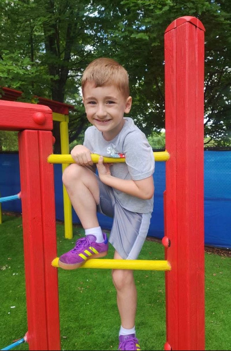 A child climbing on the outdoor play structure