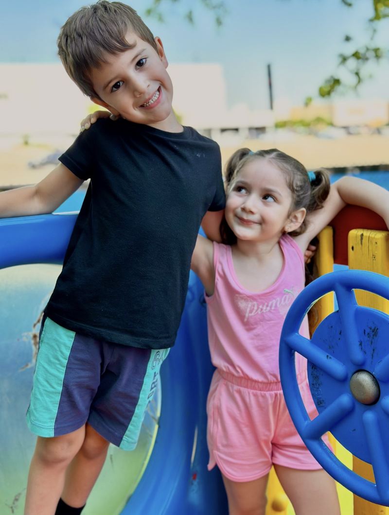 Two children smiling on the playground